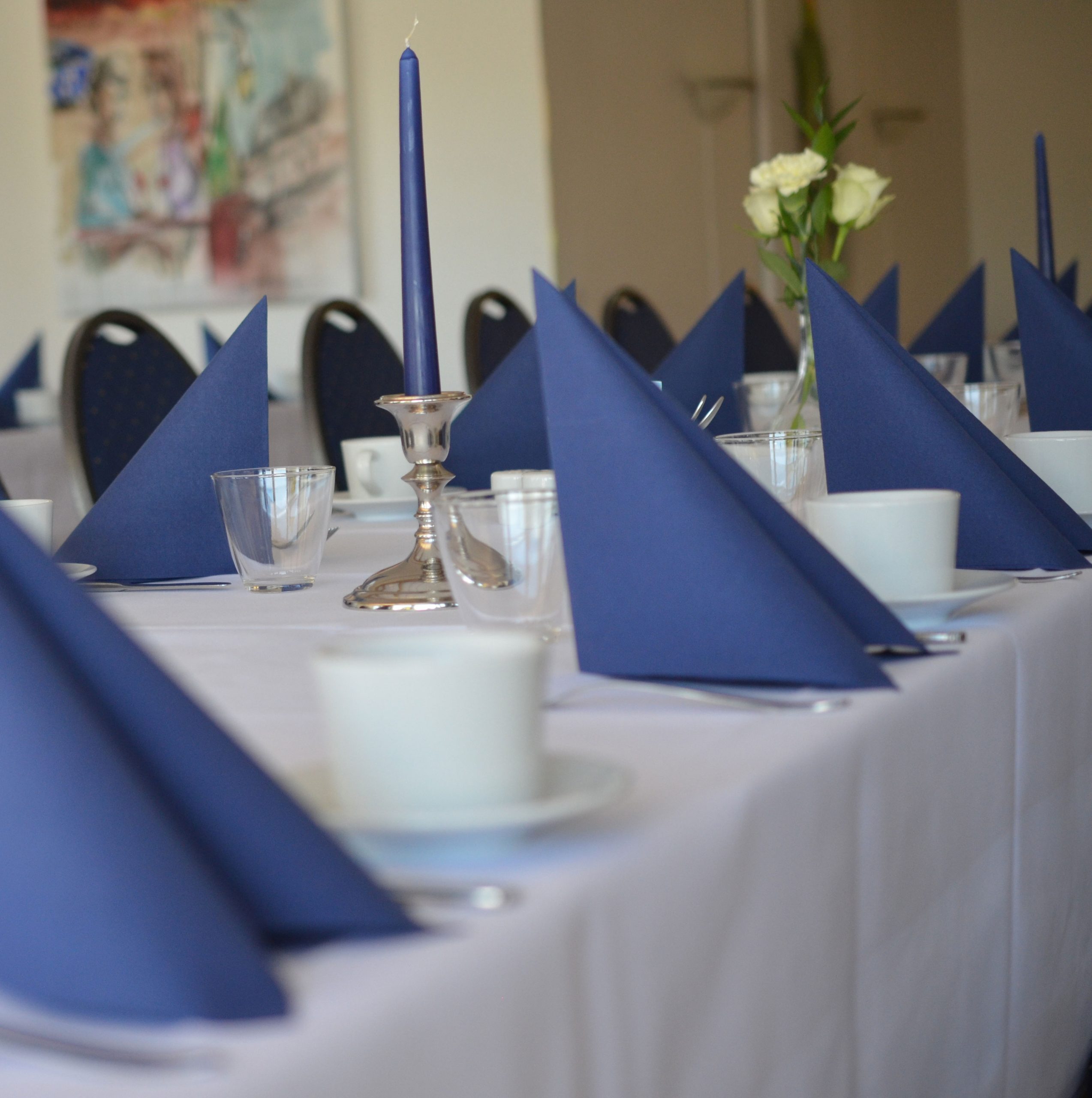 bord dækket op med kaffekopper og blå servietter